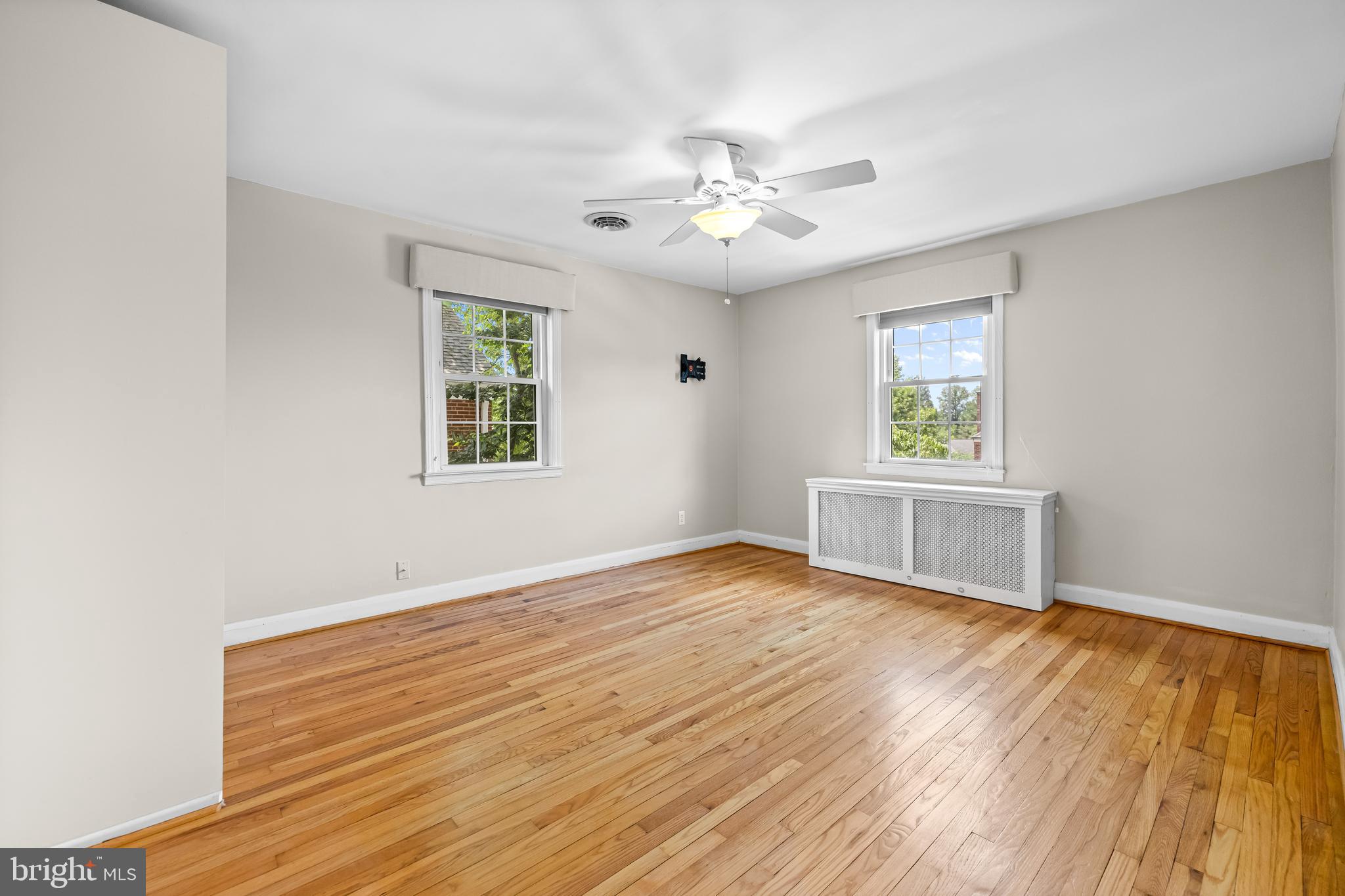 6449 Blenheim Road Baltimore, MD 21212 - Photo 22 of 36 a view of an empty room with a window and wooden floor
