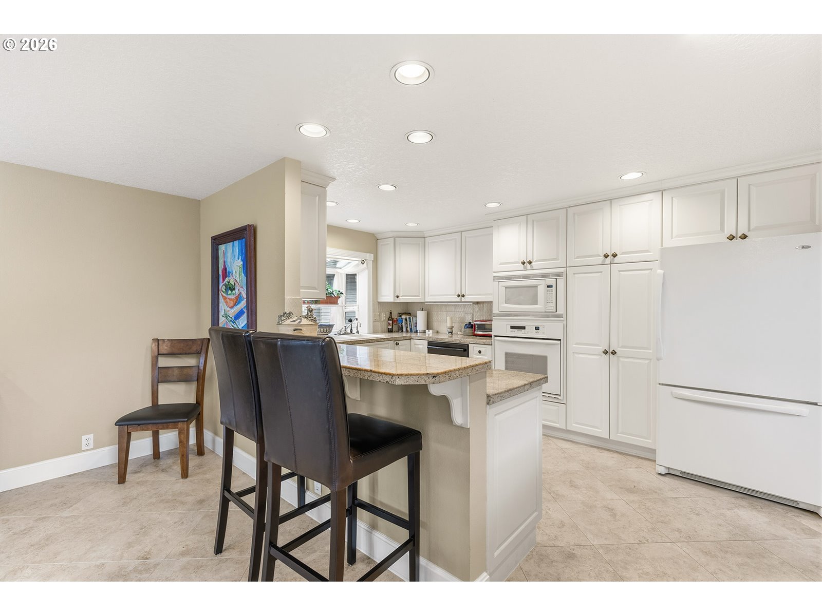 15917 Northeast Union Road, Unit 16 Ridgefield, WA 98642 - Photo 13 of 47 a kitchen with a dining table chairs refrigerator and cabinets