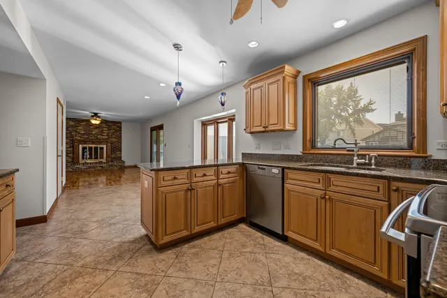 a large kitchen with stainless steel appliances granite countertop a sink and cabinets