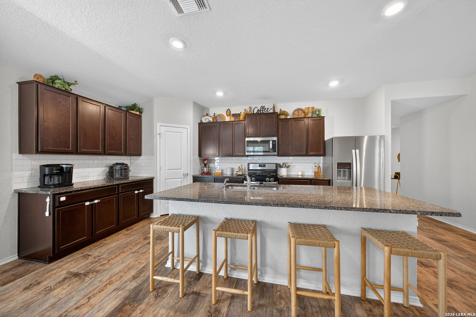 3653 Copper River Bulverde, TX 78163 - Photo 2 of 25 a large kitchen with kitchen island granite countertop wooden cabinets and stainless steel appliances