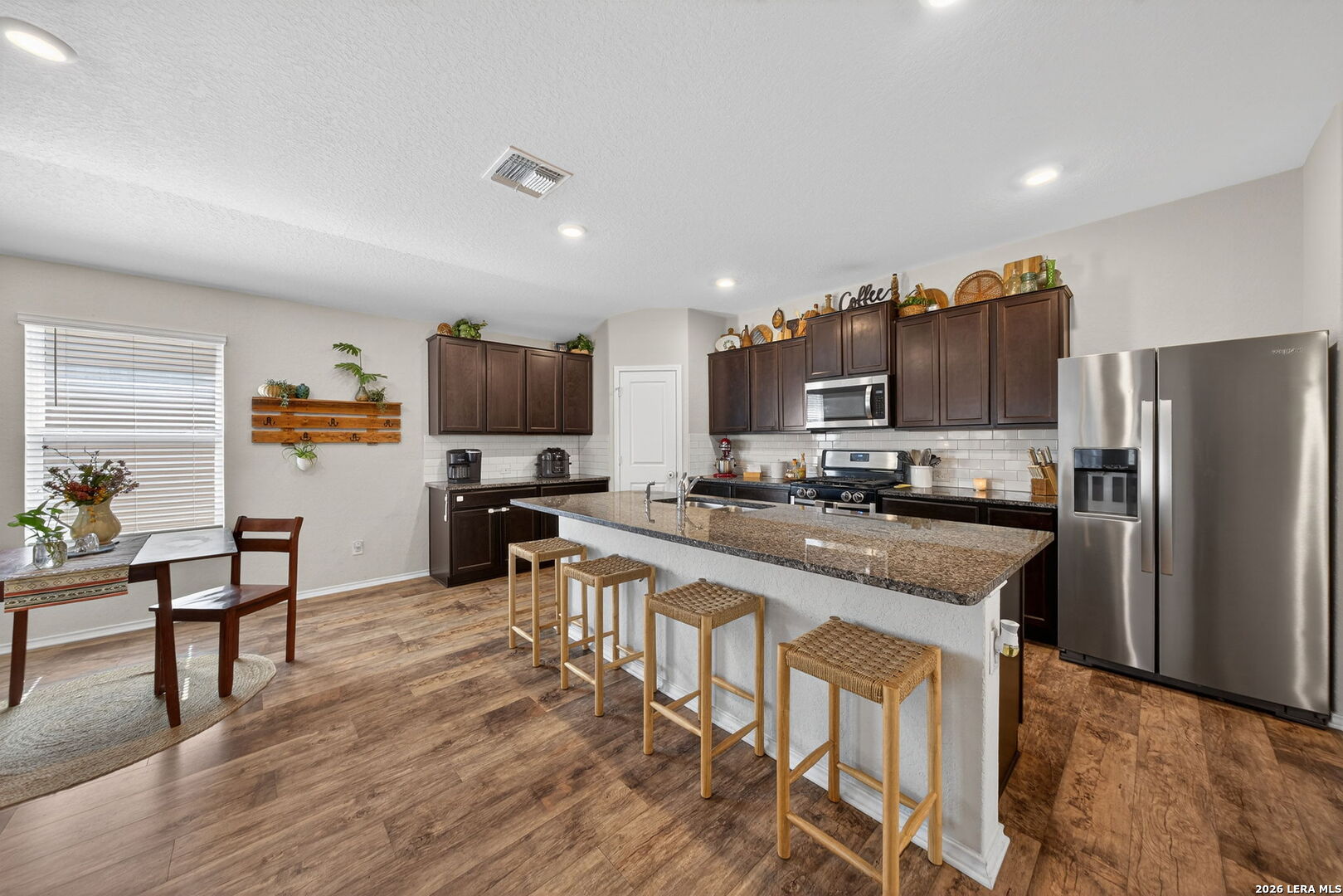 3653 Copper River Bulverde, TX 78163 - Photo 3 of 25 a kitchen with stainless steel appliances a microwave a stove a sink dishwasher a refrigerator and cabinets with wooden floor