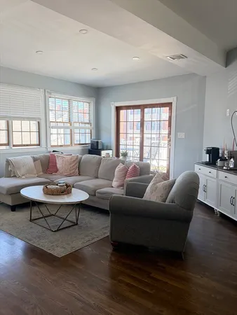 a living room with furniture a rug and a large window