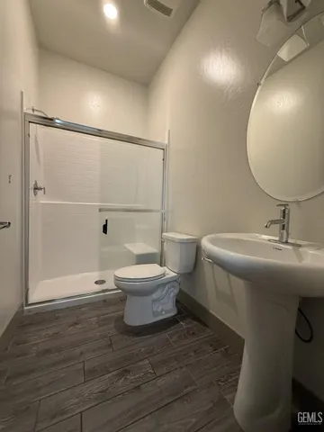 a bathroom with a sink a toilet and shower