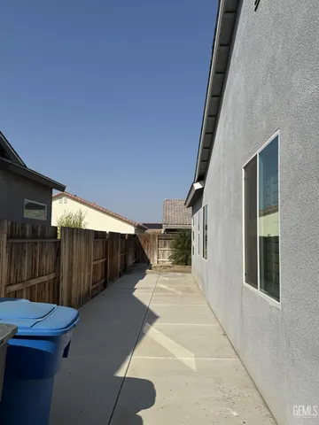 a view of a backyard with table and chairs with wooden fence