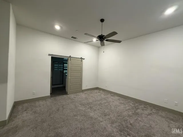 an empty room with a ceiling fan and entryway