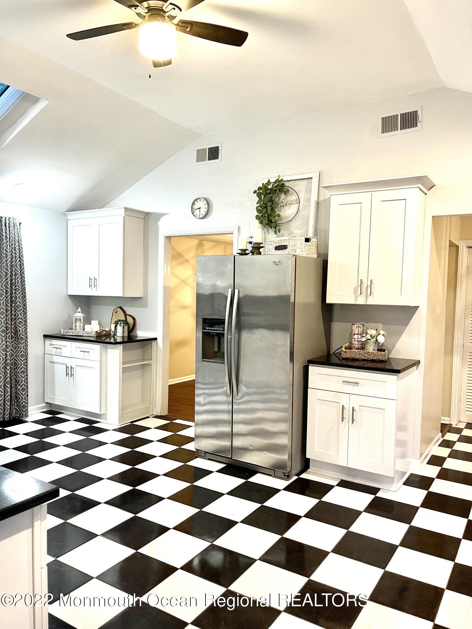641 Thoroughfare Road Brick, NJ 08724 - Photo 28 of 48 a kitchen with a checkered floor and white cabinets