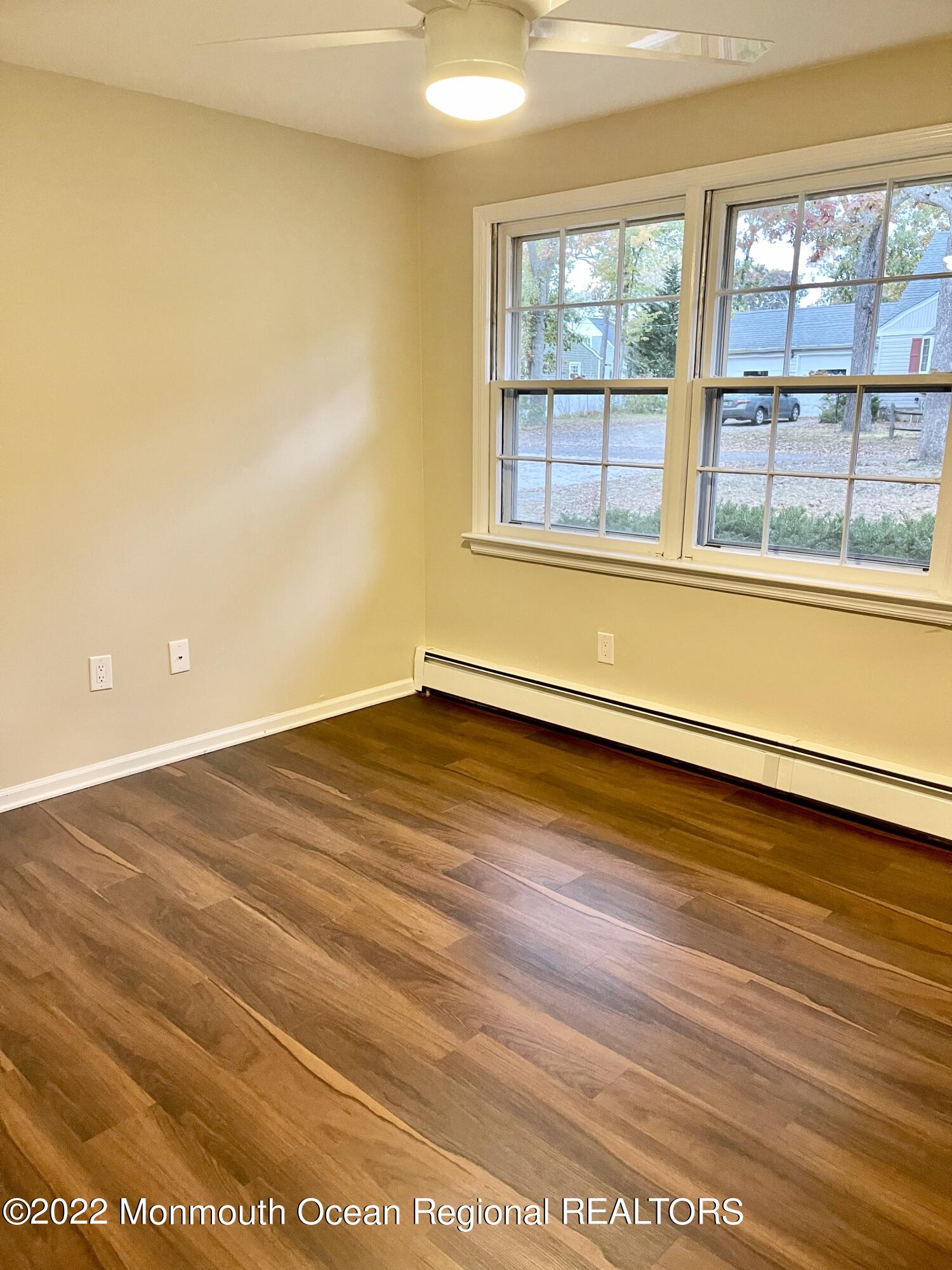641 Thoroughfare Road Brick, NJ 08724 - Photo 41 of 48 a view of an empty room with wooden floor and a window