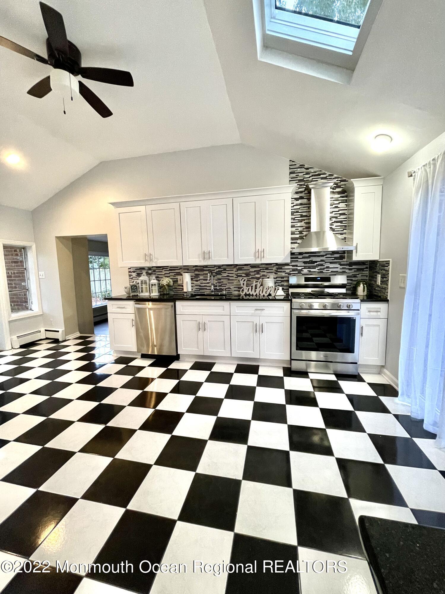 641 Thoroughfare Road Brick, NJ 08724 - Photo 5 of 48 a kitchen with a checkered floor and white cabinets