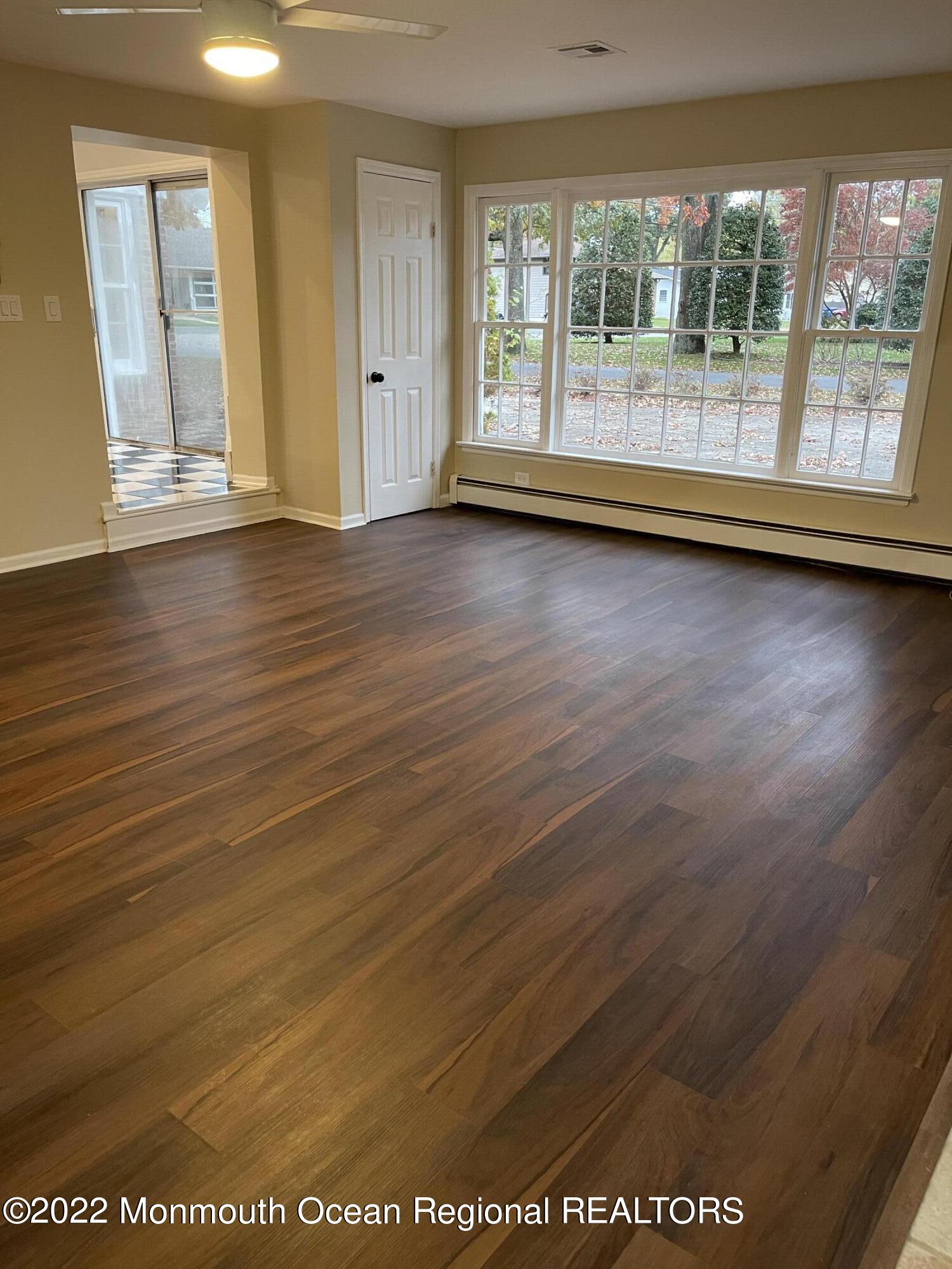 641 Thoroughfare Road Brick, NJ 08724 - Photo 10 of 48 an empty room with wooden floor and windows