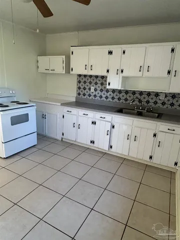 a kitchen with white cabinets and appliances