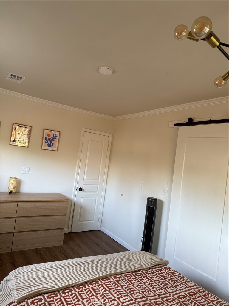 3359 Locust Street Riverside, CA 92501 - Photo 13 of 23 a bedroom with a bed and wooden floor