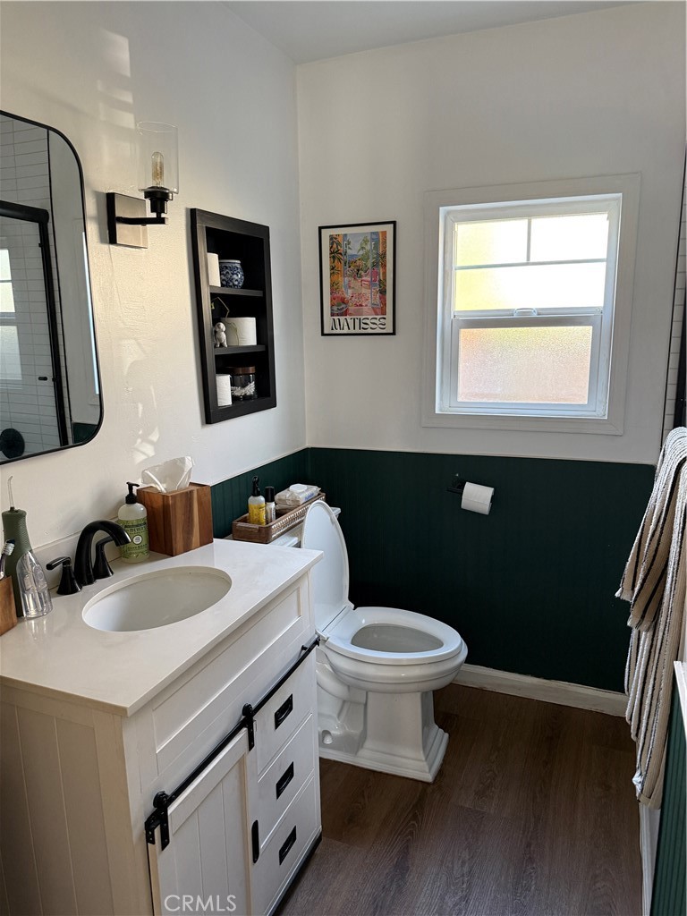 3359 Locust Street Riverside, CA 92501 - Photo 18 of 23 a bathroom with a toilet a sink a mirror and a window
