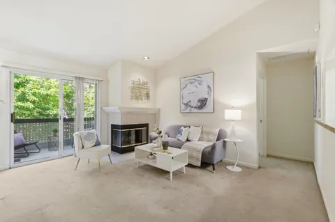 a living room with furniture a fireplace and a large window