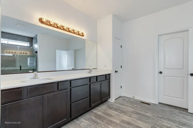 a spacious bathroom with a double vanity sink and a mirror