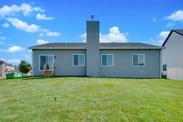 a view of a house with a yard and a large tree