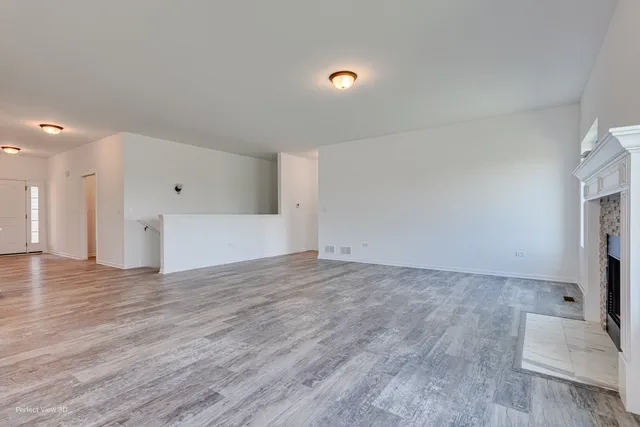 a view of a livingroom with wooden floor and staircase