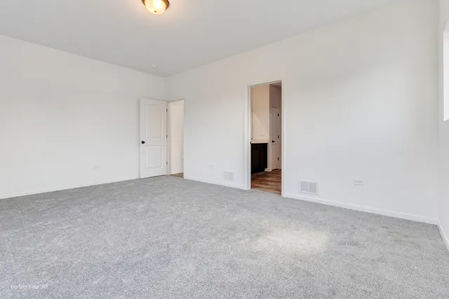 a view of an empty room with closet and a window