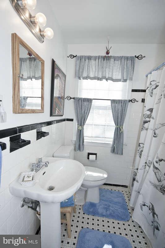198 Stanmore Road Baltimore, MD 21212 - Photo 19 of 24 a bathroom with a sink a toilet and a mirror