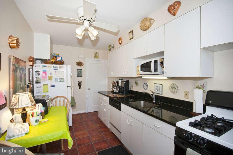 198 Stanmore Road Baltimore, MD 21212 - Photo 8 of 24 a kitchen with cabinets a stove a sink and a chandelier