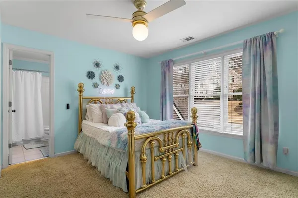 a spacious bedroom with a large bed a chandelier and closet
