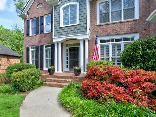 front view of a brick house with a yard