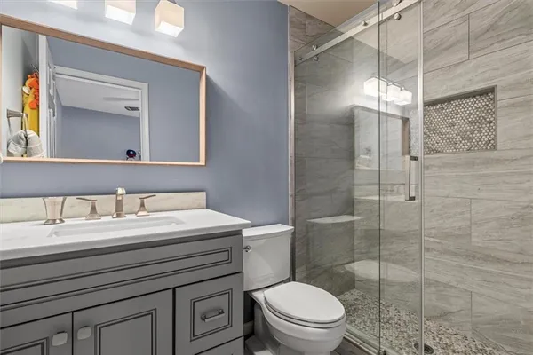 a bathroom with a toilet a sink and a mirror