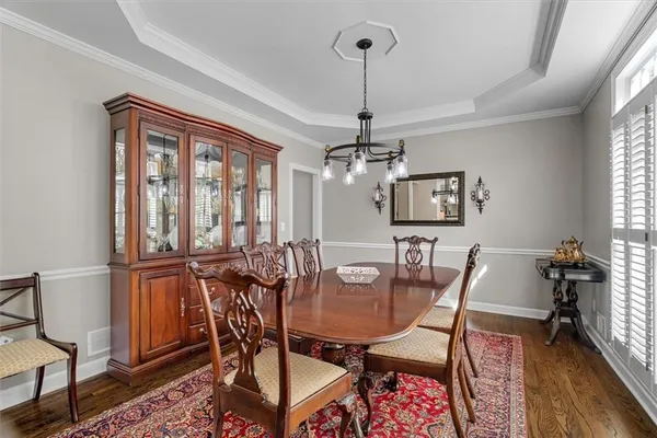 a view of a dining room and livingroom with furniture wooden floor a chandelier