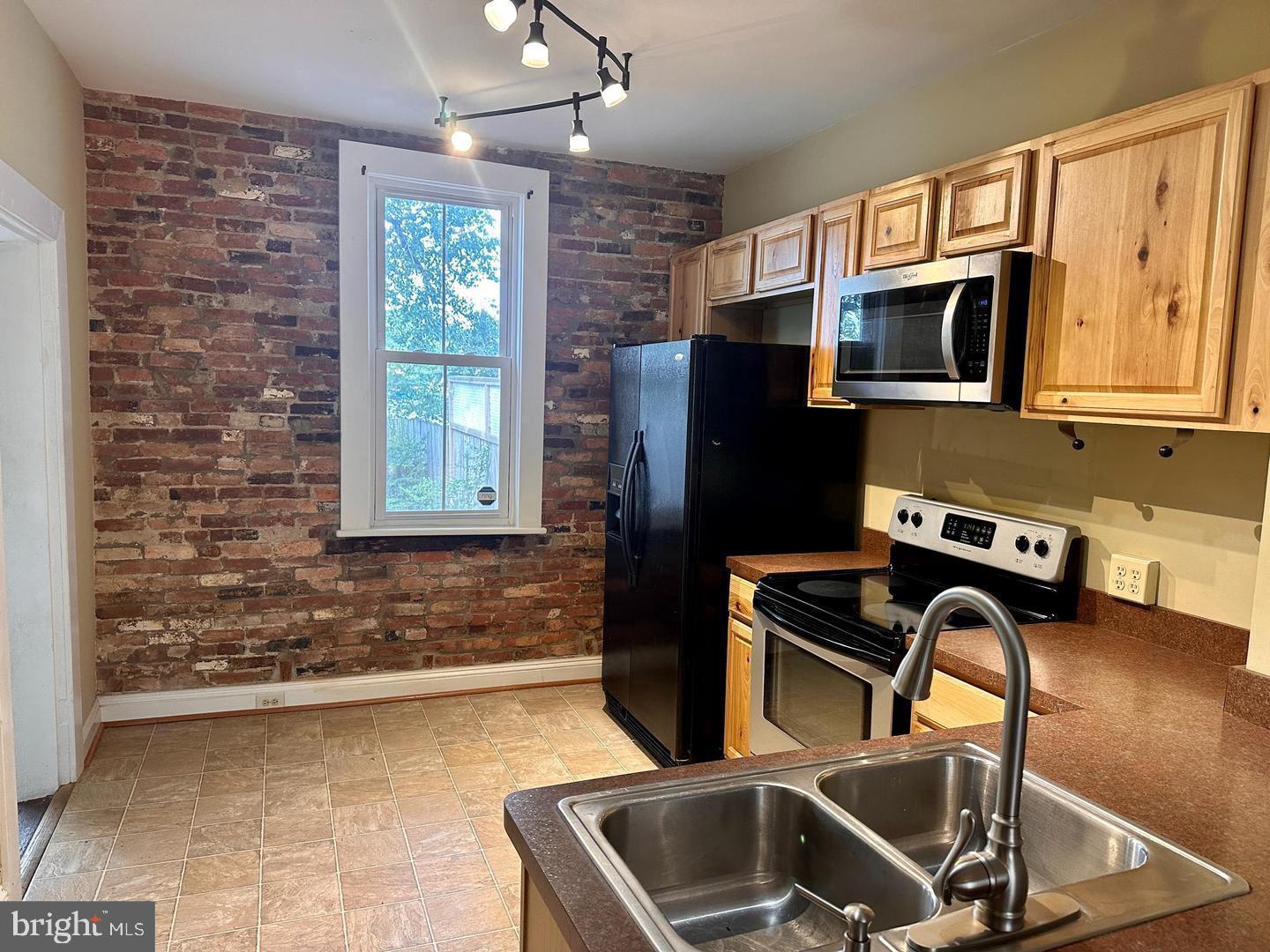 313 North Kent Street Winchester, VA 22601 - Photo 2 of 15 a kitchen with a refrigerator wooden floor and a window