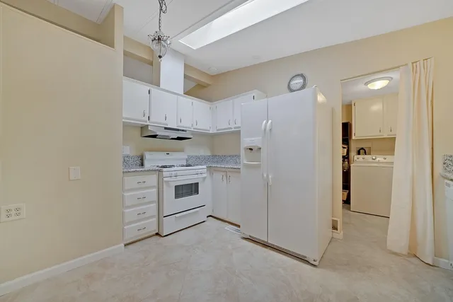a kitchen with cabinets appliances and a ceiling fan