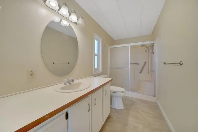 a bathroom with a sink a toilet and a mirror