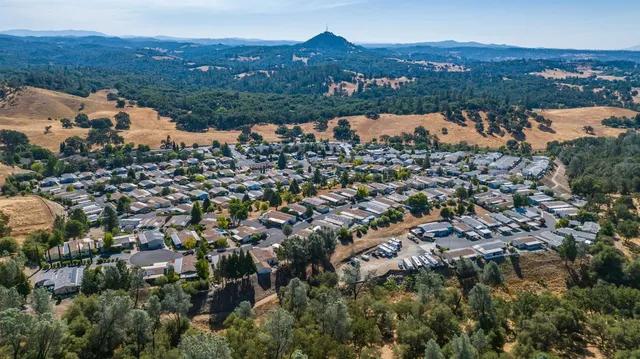 an aerial view of residential houses with outdoor space and trees
