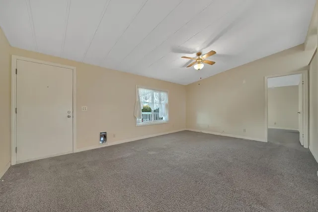 an empty room with closet and a ceiling fan