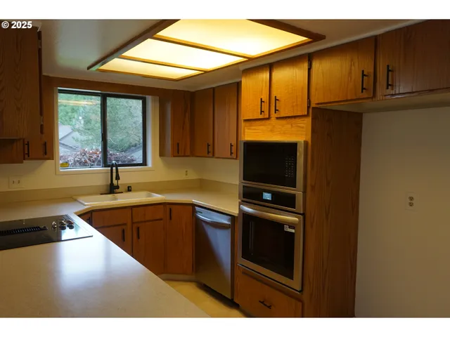 a kitchen with stainless steel appliances granite countertop a sink and a microwave