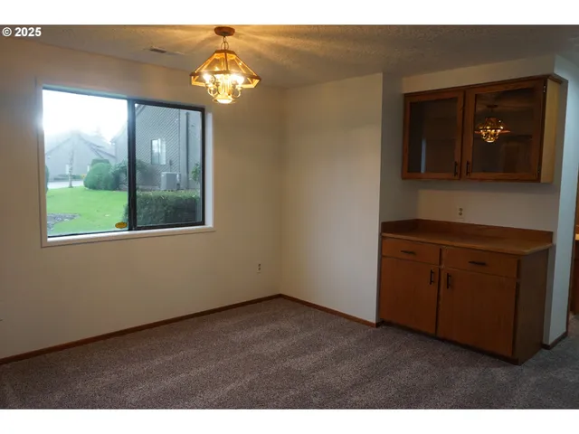 a living room with a large window and a chandelier
