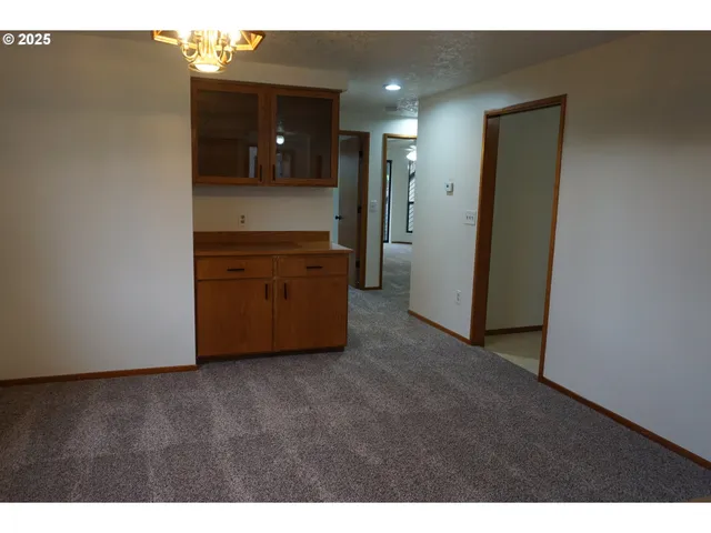 a view of an empty room with closet and mirror