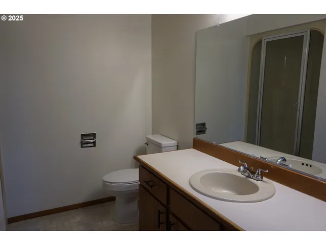 a bathroom with a granite countertop sink toilet and mirror