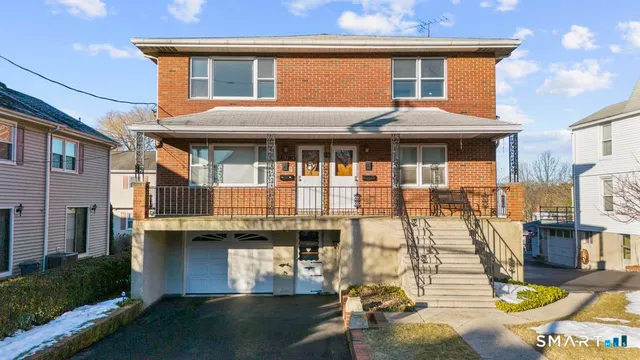 a view of a white house with large windows and a table and chairs