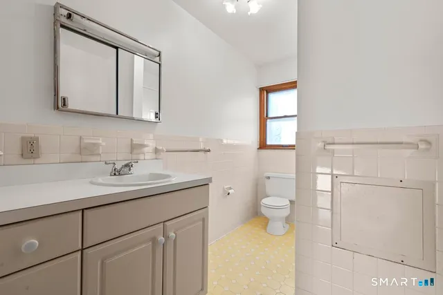 a bathroom with a toilet sink and mirror
