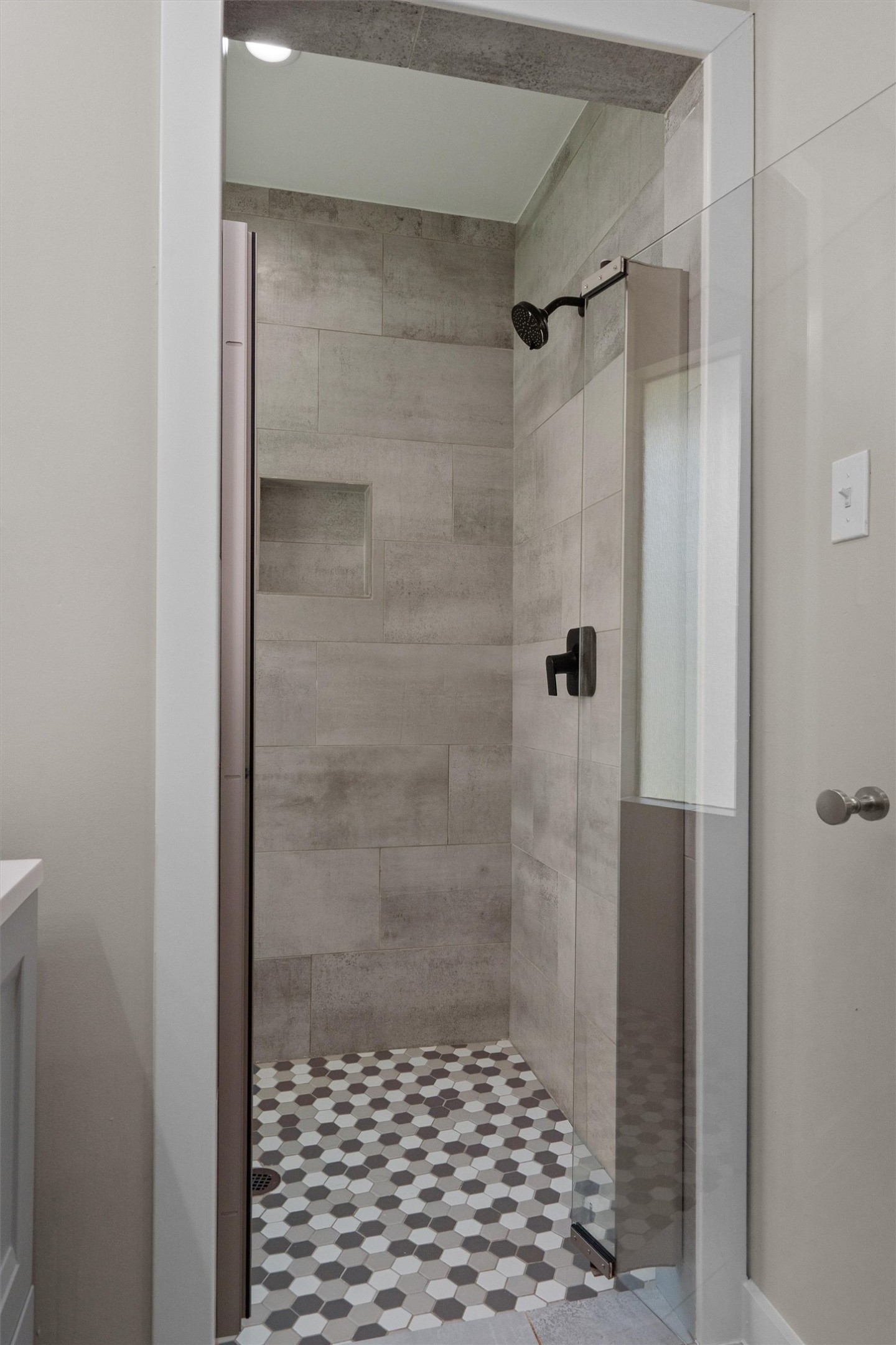 7707 Robalo Road Austin, TX 78757 - Photo 16 of 33 A contemporary shower stall features large format wall tiles and a striking hexagonal mosaic floor.
