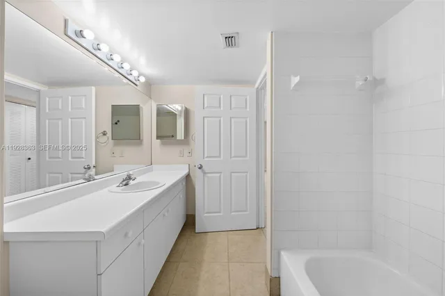 a spacious bathroom with a bathtub shower sink double and mirror