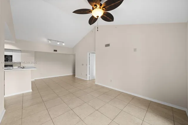 a view of an empty room and kitchen view