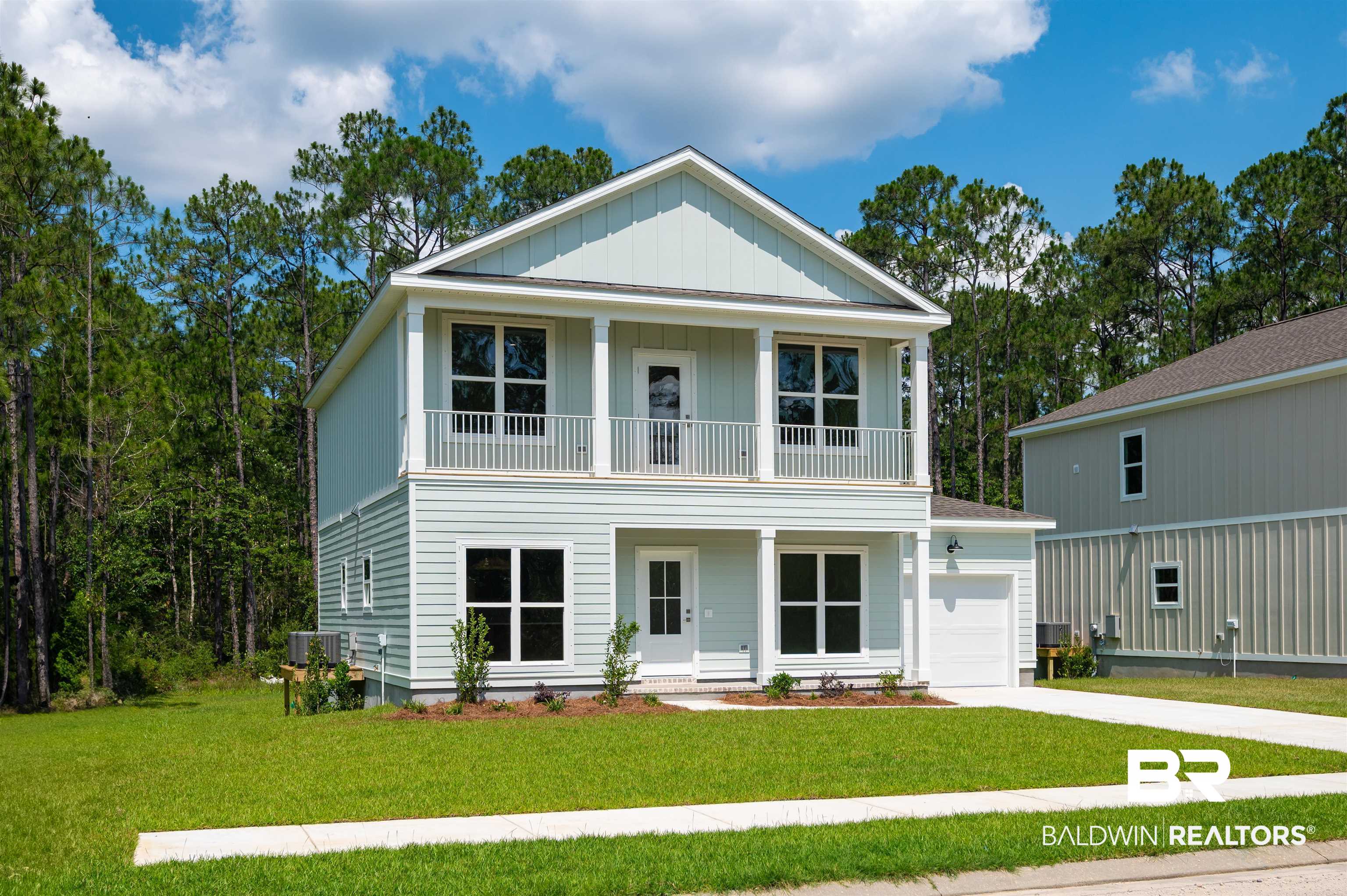 657 Island Way Gulf Shores, AL 36542 - Photo 36 of 59 View of front of house with a balcony, an attached garage, board and batten siding, covered porch, and central air condition unit