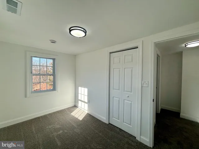 an empty room with windows and closet
