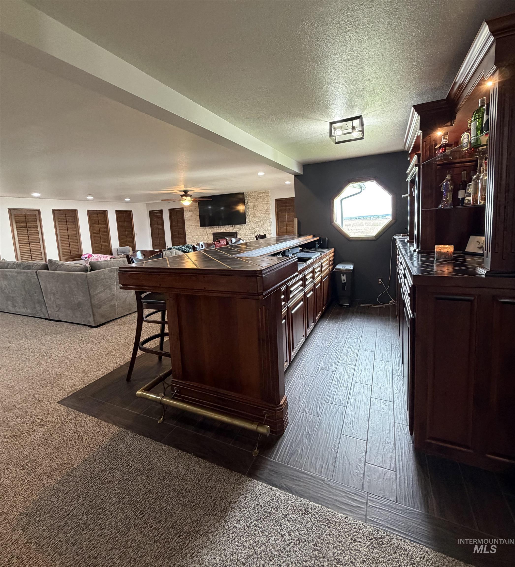 880 Jenkins Creek Road Weiser, ID 83672 - Photo 12 of 43 Custom built-in bar featuring wood cabinetry, a tiled countertop, and an octagonal window