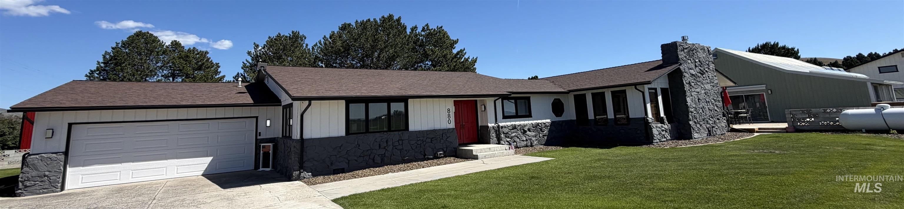 880 Jenkins Creek Road Weiser, ID 83672 - Photo 2 of 43 Ranch-style residence featuring a dark shingle roof, white vertical siding, and dark stone accents