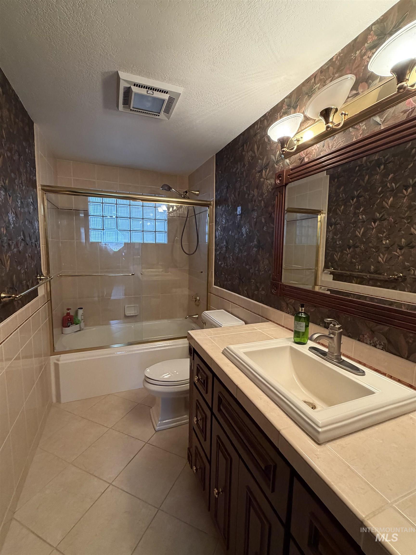 880 Jenkins Creek Road Weiser, ID 83672 - Photo 23 of 43 Bathroom featuring a dark wood-finish vanity with an integrated sink, a tiled countertop, and a vanity mirror with overhead lighting