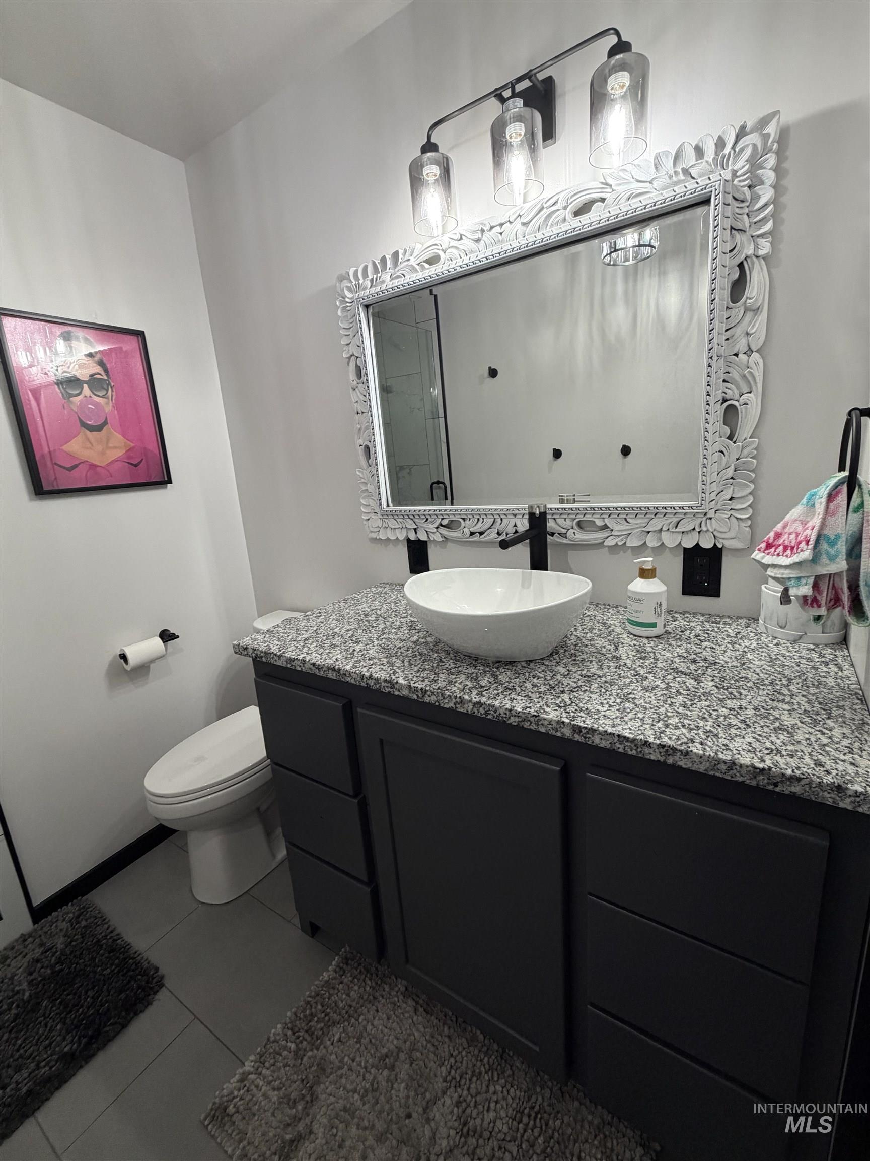880 Jenkins Creek Road Weiser, ID 83672 - Photo 29 of 43 Bathroom vanity featuring a vessel sink, dark cabinetry with ample storage, a granite countertop, and an ornate framed mirror