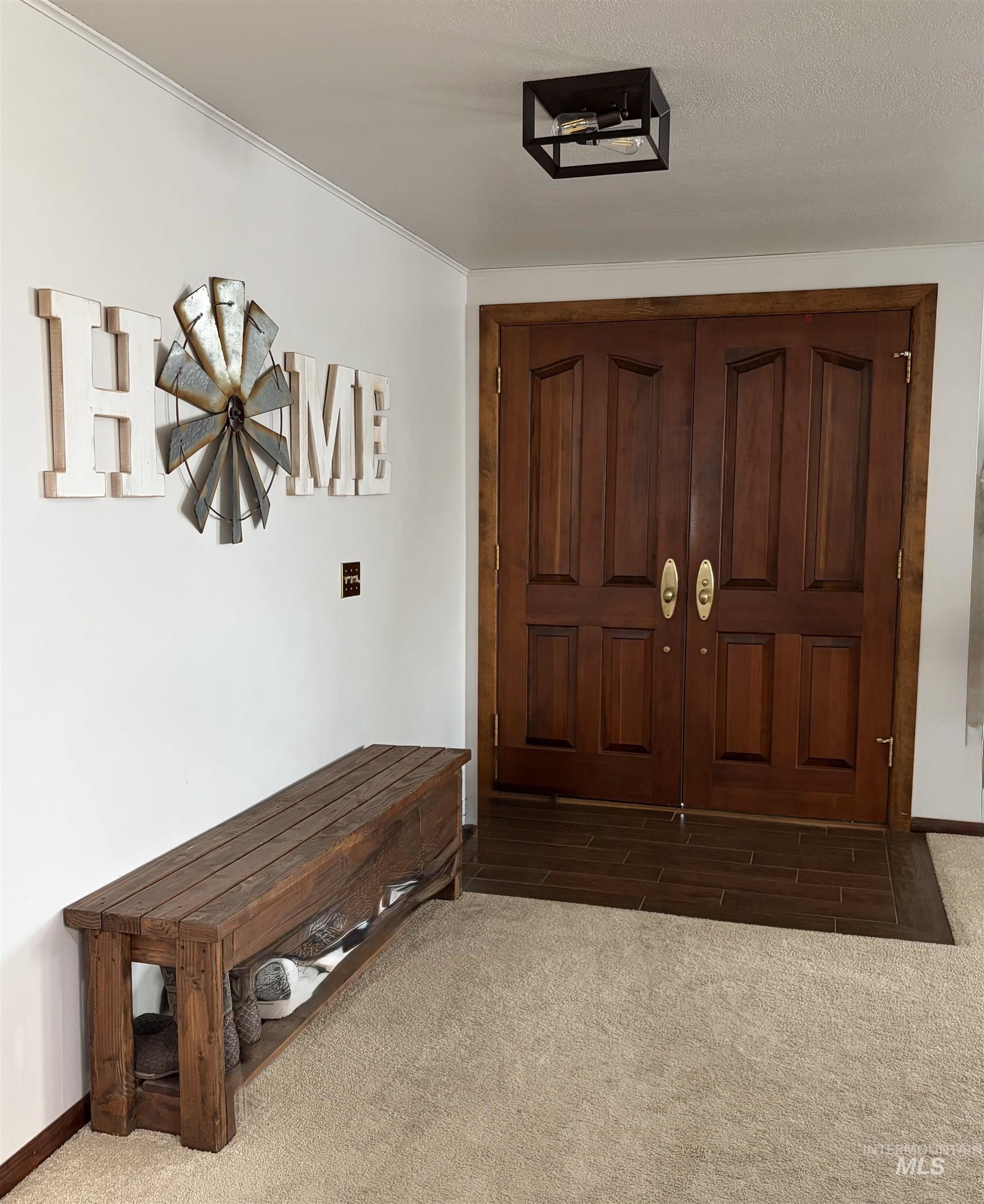 880 Jenkins Creek Road Weiser, ID 83672 - Photo 3 of 43 Entryway featuring a double wood-panel door with brass hardware, wood-finish tile flooring, a flush-mount ceiling light with a metal frame, and crown molding