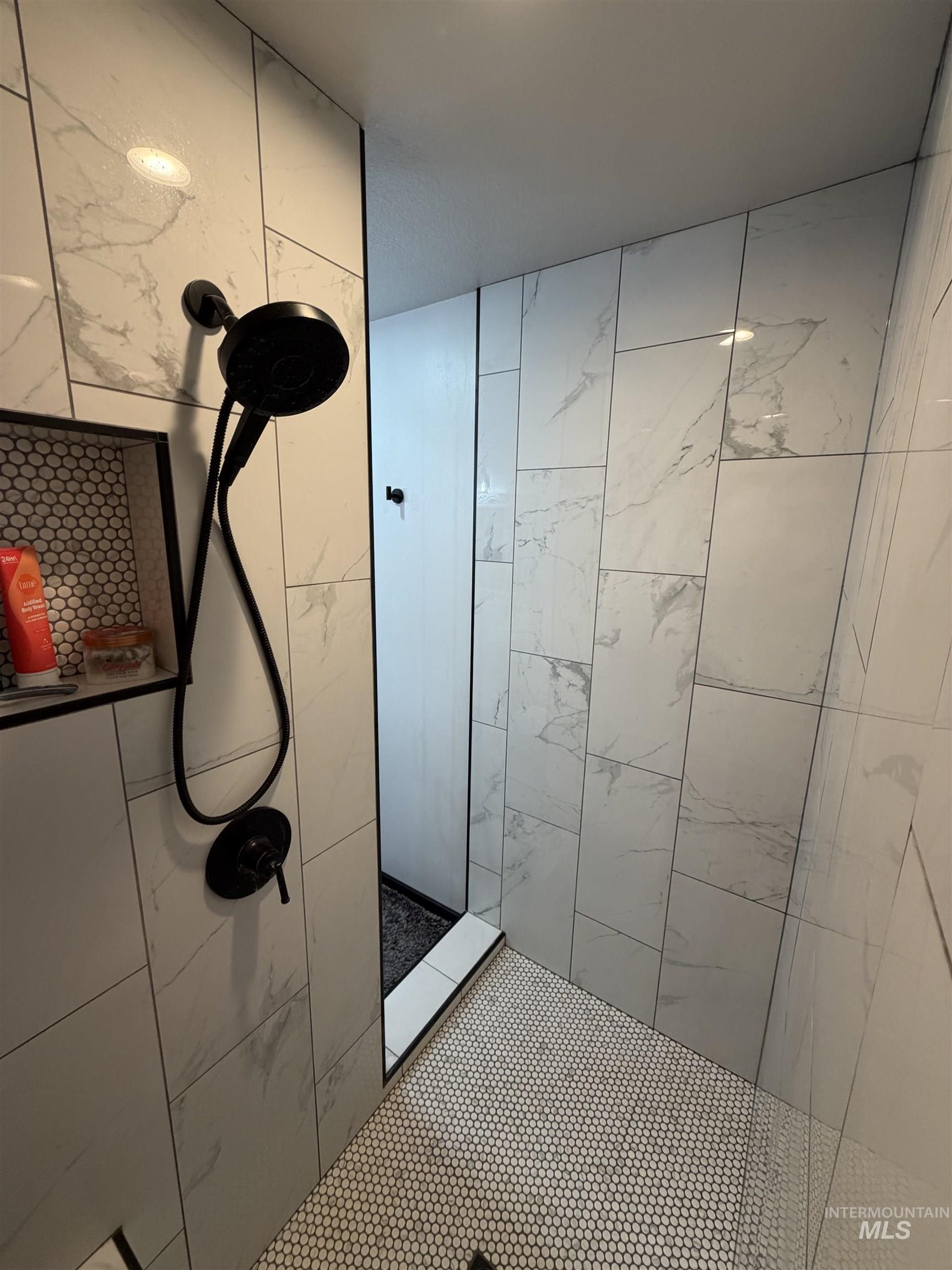 880 Jenkins Creek Road Weiser, ID 83672 - Photo 31 of 43 Shower with white marble-look subway tile walls, black matte shower fixtures, and a built-in recessed niche featuring a mosaic penny tile backer