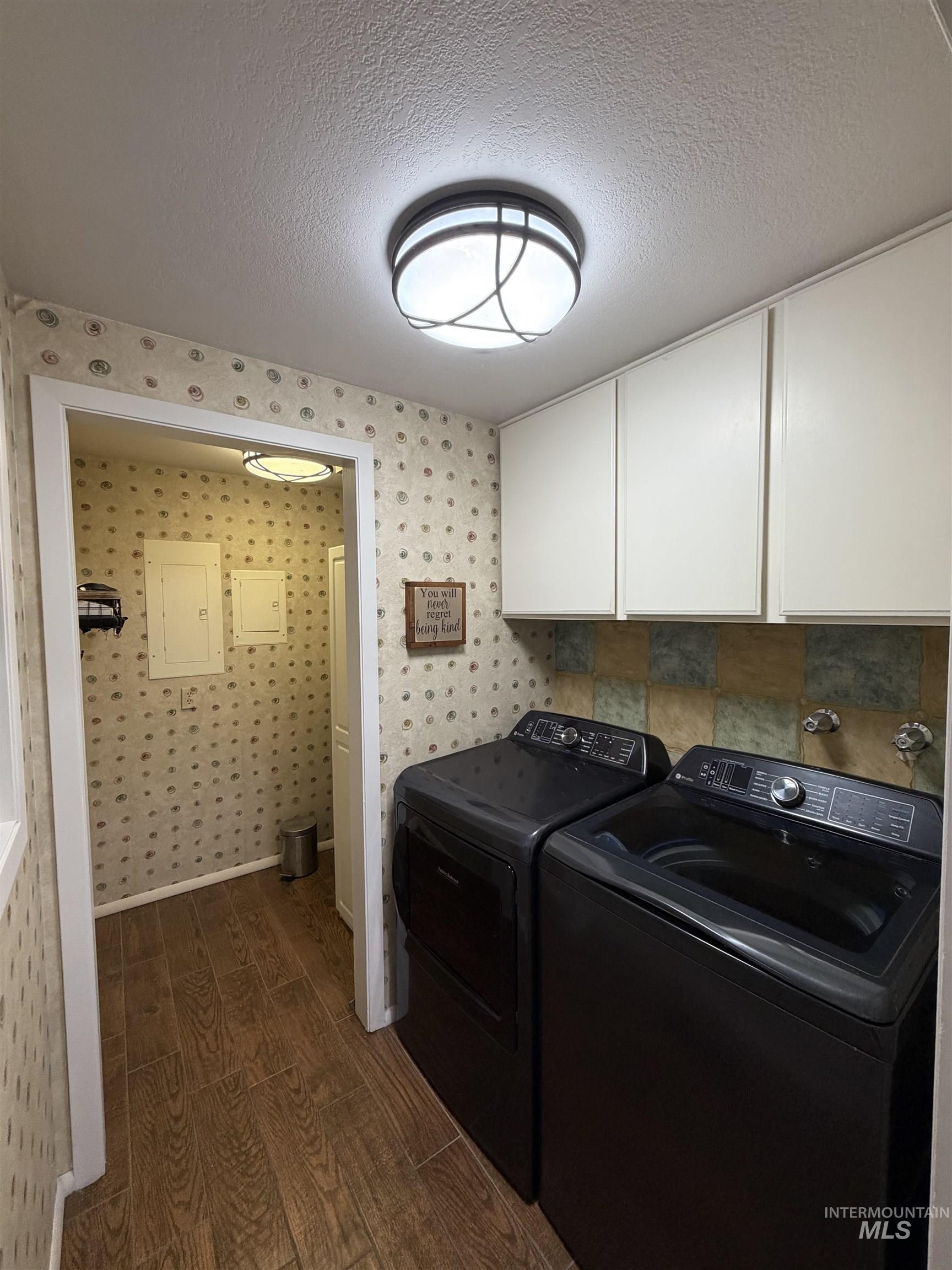 880 Jenkins Creek Road Weiser, ID 83672 - Photo 34 of 43 Laundry area featuring wood-finish flooring, white upper cabinetry, and a patterned wall covering